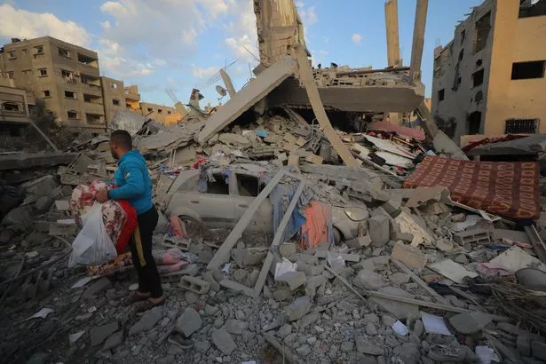 People looking for belongings in the rubble