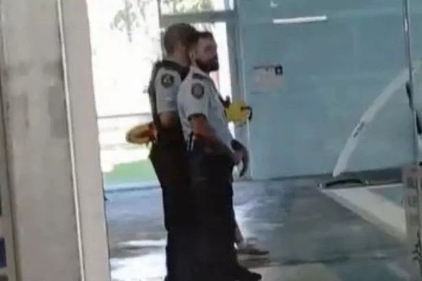 Two policemen standing by the pool