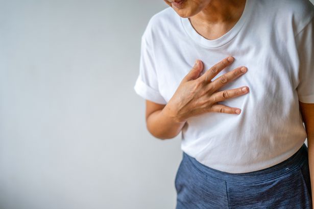 Person clutching chest having a heart attack