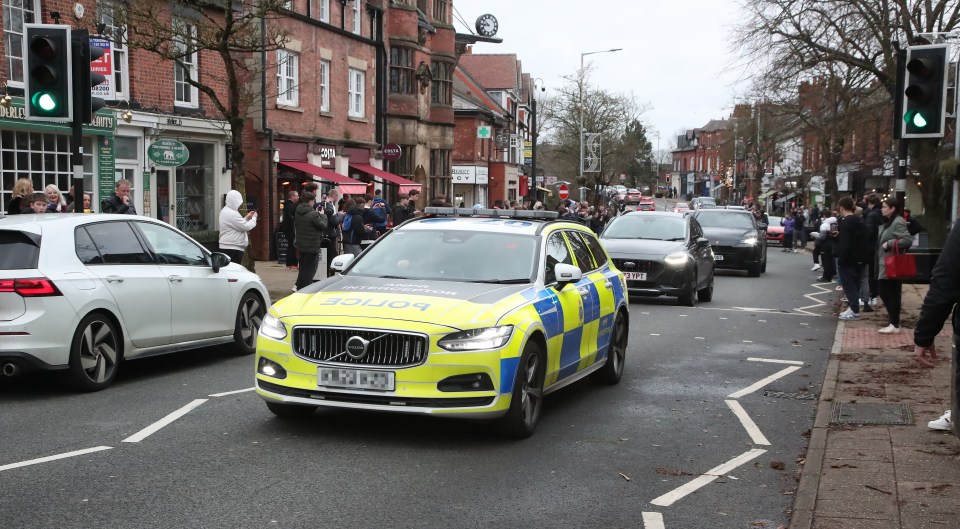 Police car dispersing a crowd of onlookers.