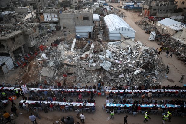 This aerial photograph shows Palestinians gathered for a communal iftar fast-breaking meal, amid the devastation in the