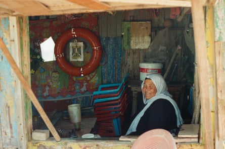 An older woman sitting in a beach kiosk 