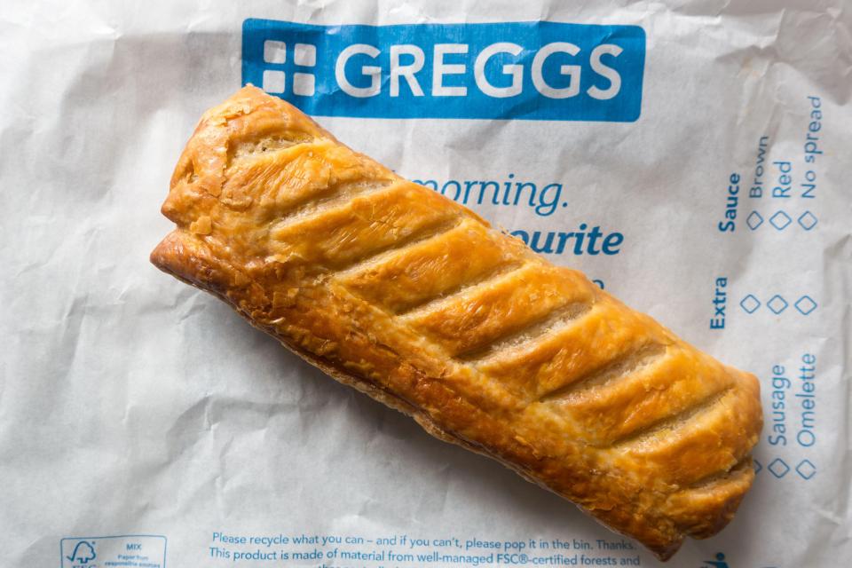 Greggs sausage roll on a Greggs bag.