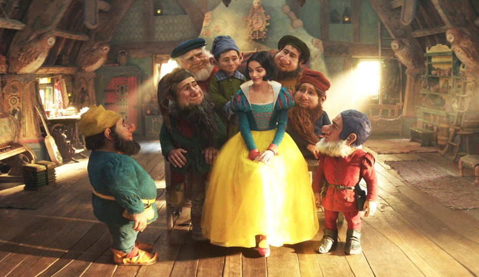 Snow White with the seven dwarfs in their cottage.