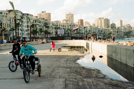 Children ride their bikes between concrete blocks on Alexandria’s corniche.