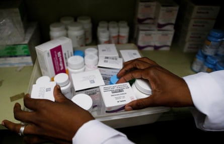 A person’s hands handling packets of pills