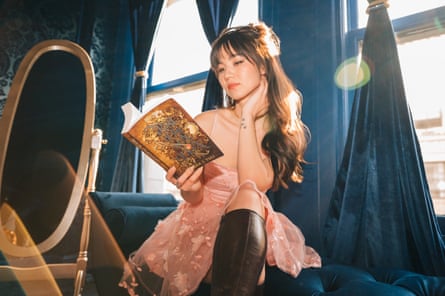 a woman in a pink dress reads a book