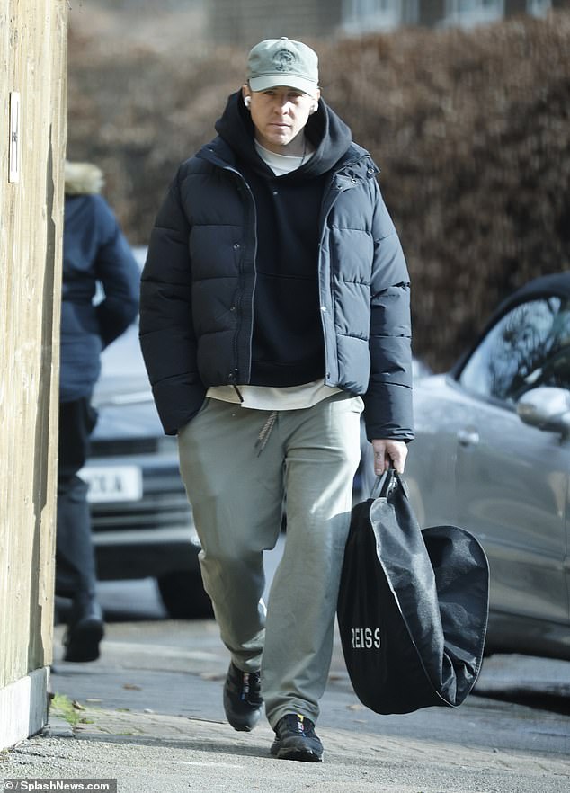 He dressed casually in a tracksuit and wore headphones as he carried a suit bag to a dry cleaners in west London