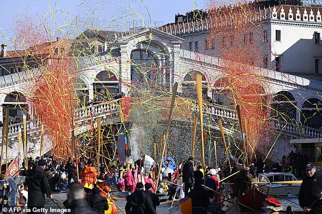 Confetti explodes as decorated boats sail on the Grand Canal in front of Rialto bridge during Venice Carnival, on February 16, 2025