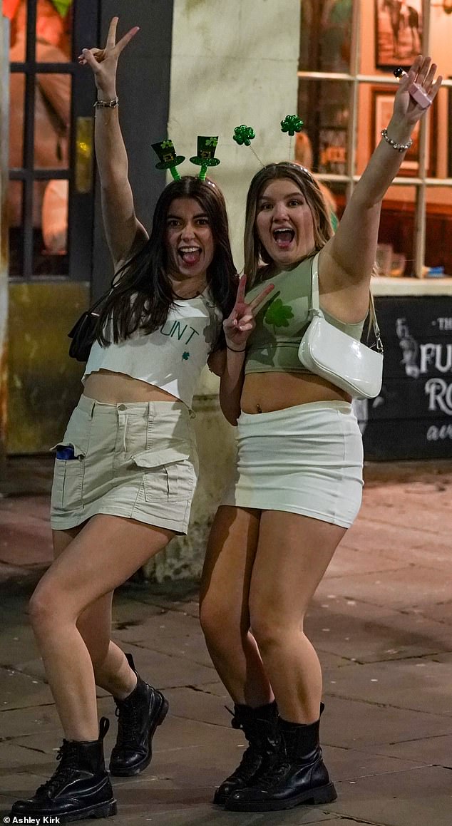 Two friends pose for the camera in leprechaun and shamrock headbands in Nottingham