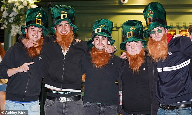 A group of friends wearing matching green hats and red fake beards in Nottingham