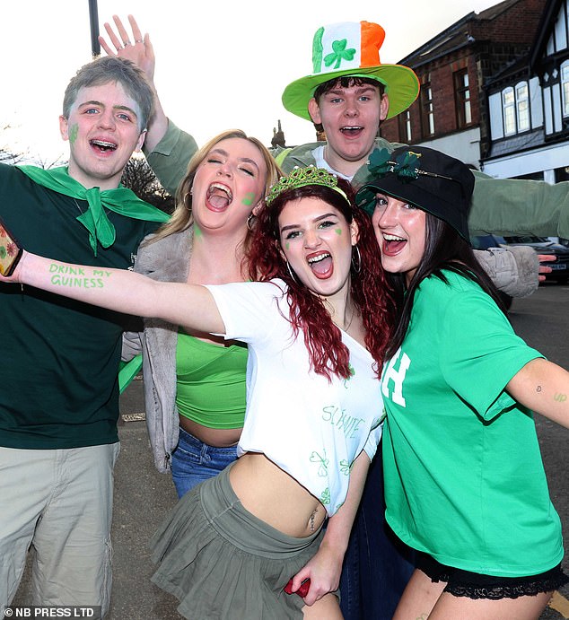 A group of friends poses for the camera, wearing Irish colours, green tops and with DIY green felt pen decorations