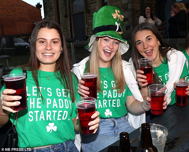 A group of friends whose tops read 'let's get the Paddy started' drinking at a bar in Leeds