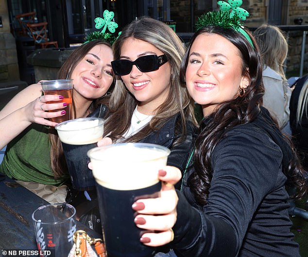 Three friends drinking pints of Guinness at a bar in Leeds