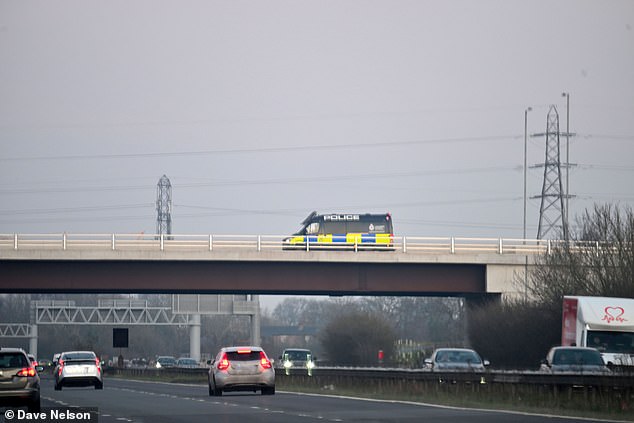 Lancashire Police have launched an urgent manhunt (Pictured: Police on the flyover at Junction 2)