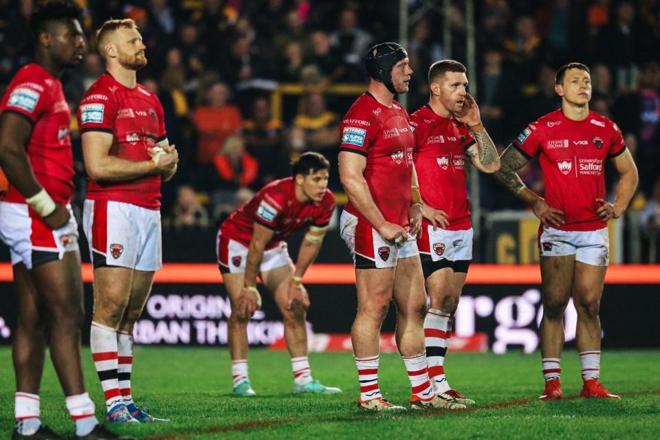 Salford Red Devils rugby players on the field after a penalty.