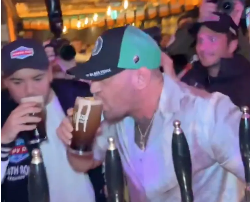 Man and boy drinking pints at a bar.