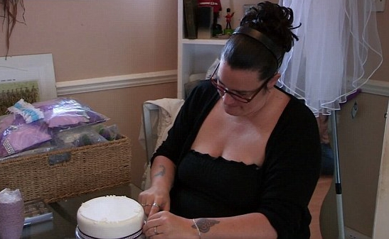 Woman decorating a wedding cake.