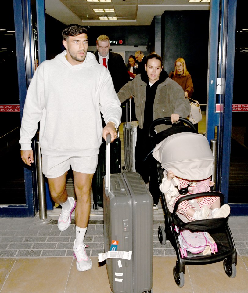 Molly Mae and Tommy Fury arriving at an airport with their baby in a stroller.