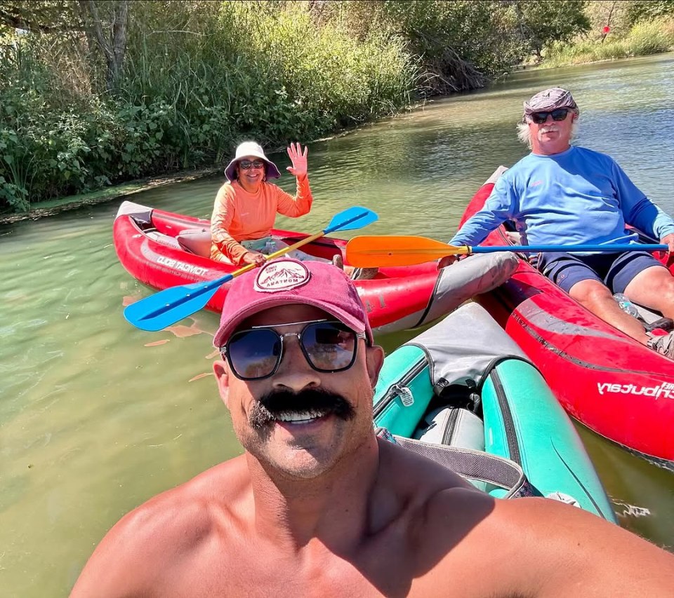 Three people kayaking on a river.