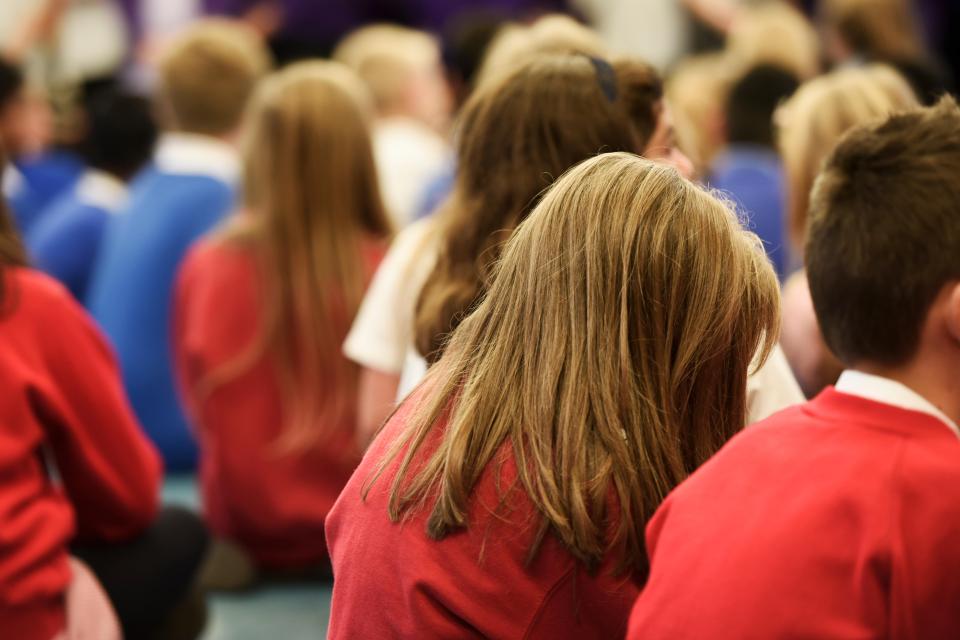 School children sitting in an assembly.