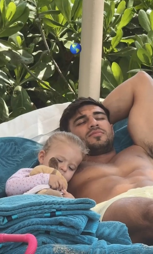 Man and toddler napping together outdoors.