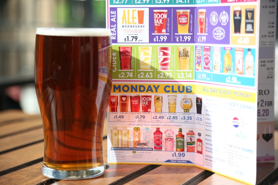 Pint of ale next to a pub menu.