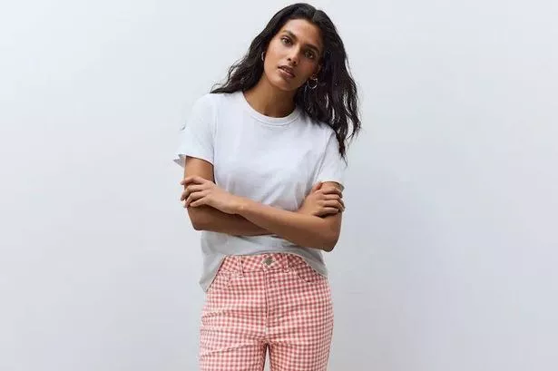Person wearing red and white gingham capri jeans