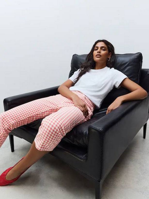 Person wearing red and white gingham jeans and a white tee