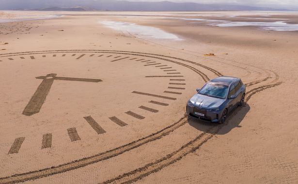 A giant sand clock, drawn using car tyres, symbolises the hours drivers could reclaim thanks to intelligent tech from BMW Proactive Care.