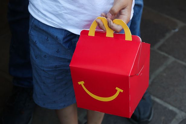 A child holds McDonald's Happy Meal box