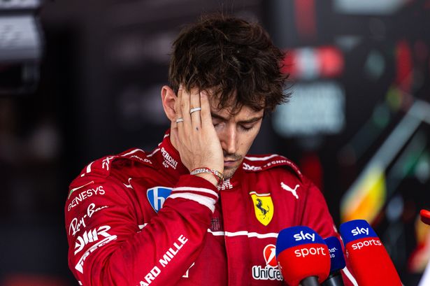 Charles Leclerc with his head in his hand in the media pen after the Hungarian Grand Prix