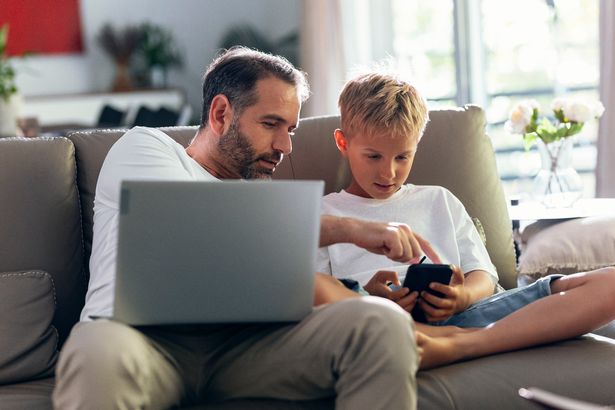 Father sat on sofa with child