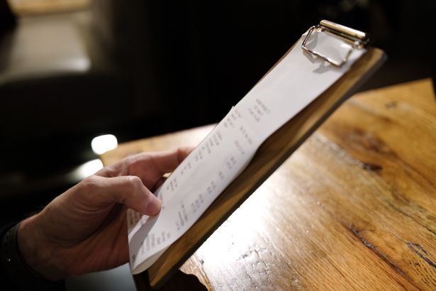 Close-up of unrecognizable man examining bill at restaurant