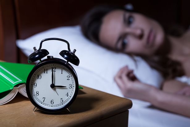 Alarm clock on night table showing 3 a.m.