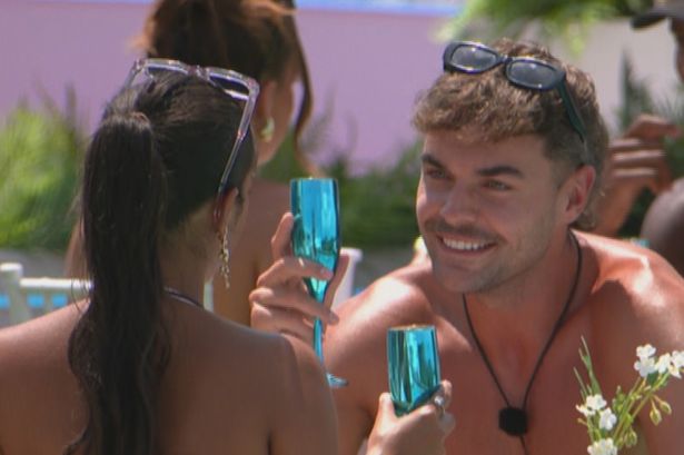 Harry Cooksley sat at a table in the villa garden on Love Island.