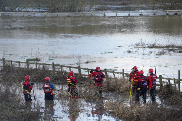 Emergency service workers searching along a bank of the River Soar, Leicestershire in June