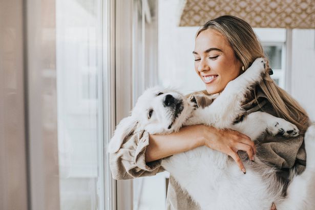 Woman holding dog like a baby
