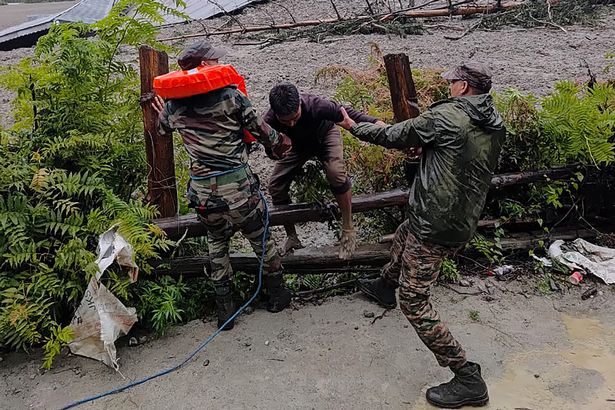 Security personnel rescuing a local resident