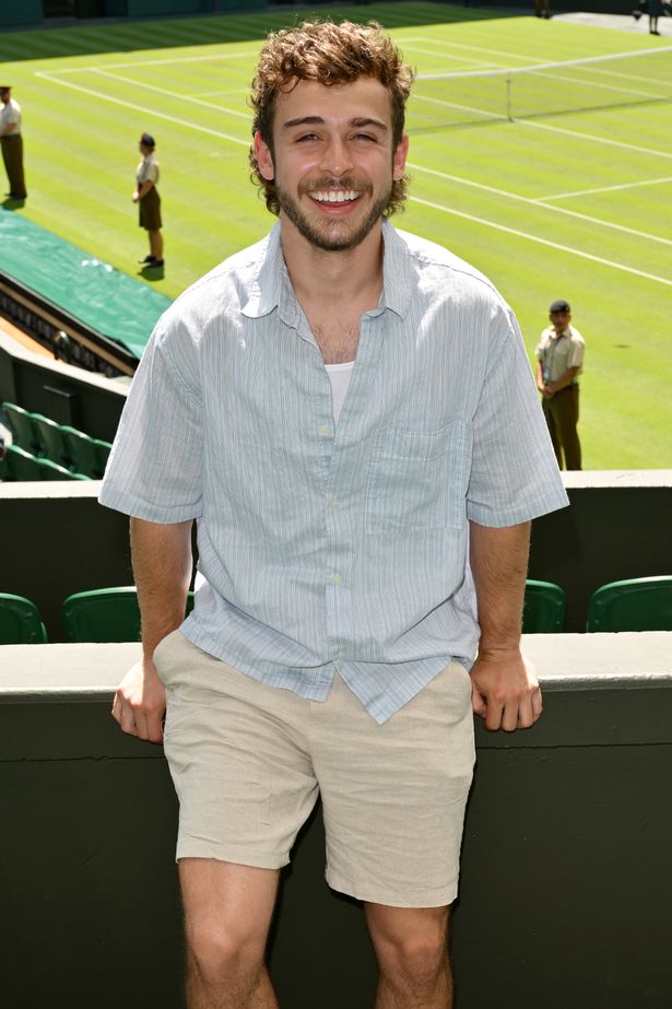 George Clarke in a blue shirt and beige shorts at Wimbledon.