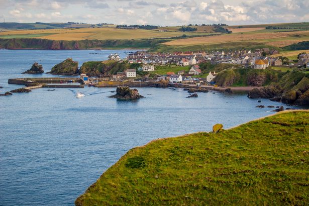 July 25, 2024 - St. Abbs, Scotland: Late afternoon view looking toward the coastal village of Saint Abbs, Scotland from the rocky cliffs of Saint Abbs Head national nature reserve in the Scottish Borders of Scotland, UK.
