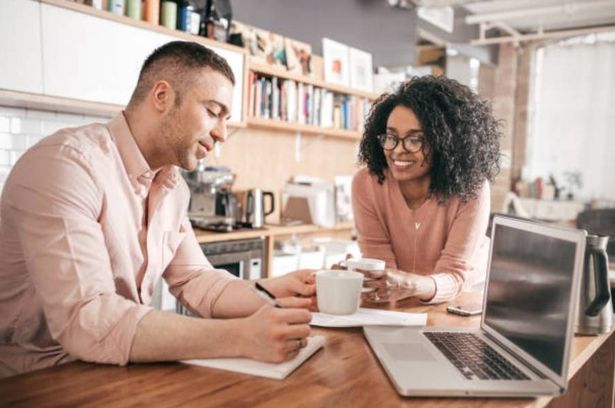 Couple doing their finances in the kitchen, laptop