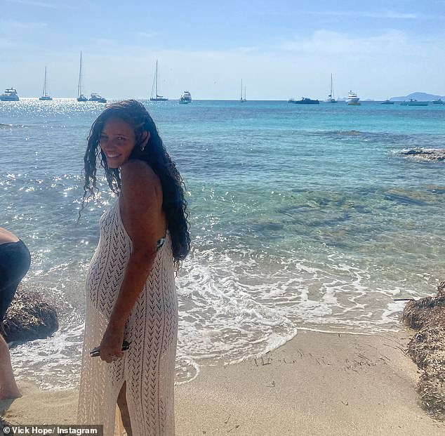 She too posed for a photo on the beach while in Ibiza, cracking a smile for the camera after slipping into a white summer dress