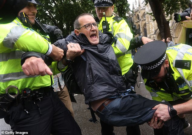 The network of protests, organised by campaign group Defend Our Juries, saw participants hold placards reading: 'I oppose genocide, I support Palestine Action'. Pictured: A protester is carried away by police at the demonstration in London on July 19
