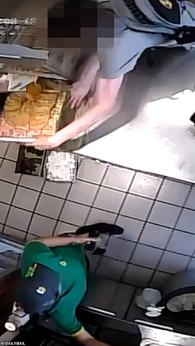Pictured: A teenager stealing a tray of cookies while a scared Subway worker watches on