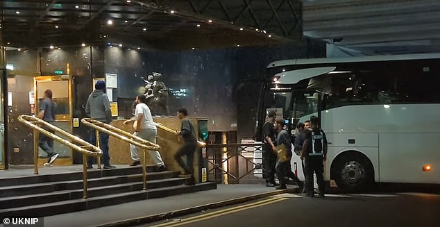 Suspected asylum seekers were last night bussed into a four-star hotel in London under the cover of darkness