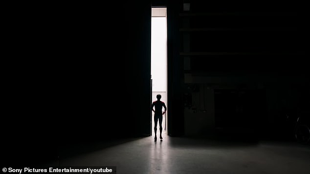 The star was seen standing front of a large doorway that began to open up with his back initially towards the camera