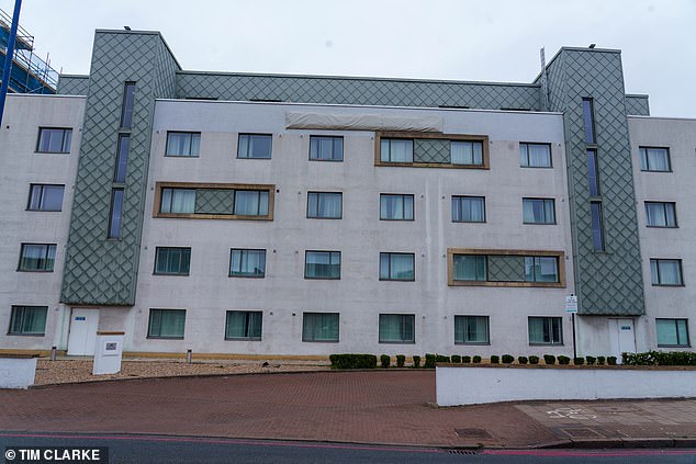 The hotel pictured in a wider shot, with many signs now removed and a sheet covering the main bit of branding at the top