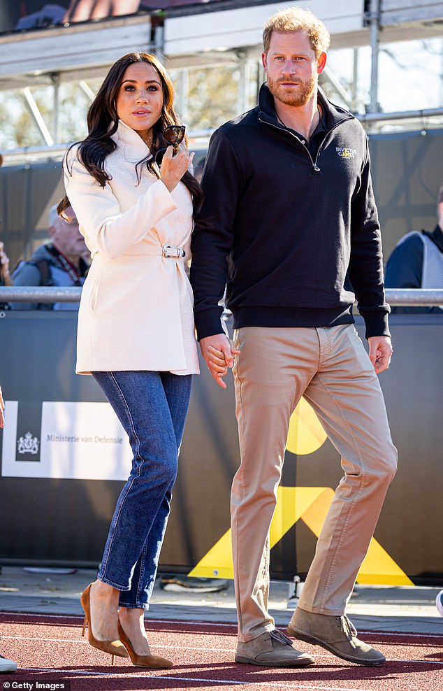 Prince Harry (pictured with Meghan Markle in April 2022) has denied having a 'physical fight' with Prince Andrew after reports punches were thrown when the disgraced Duke of York reportedly said something behind his back