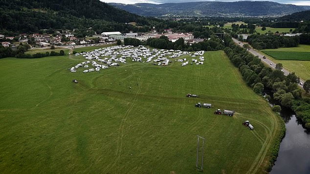 Scores of white caravans and cars can be seen parked up on the outskirts of the land - in addition to what even appears to be one red Ferrari